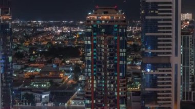 Parlak pencereler, kuleler ve arka plandaki villalar hava gece zaman çizelgesi, Dubai, Birleşik Arap Emirlikleri