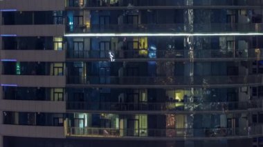 Modern ofiste büyük parlayan pencereler ve gece vakti konut binaları.