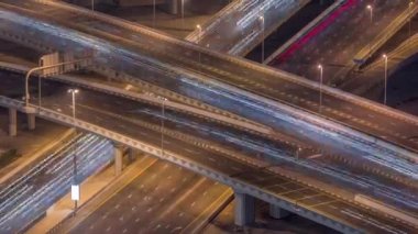 Business Bay 'de gece vakti büyük bir kavşakta şehir trafiği var..