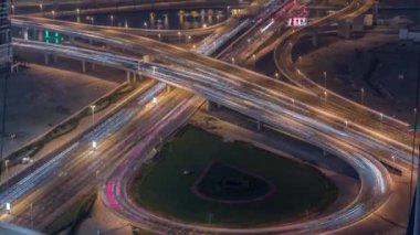 Business Bay 'de gece vakti büyük bir kavşakta şehir trafiği var..