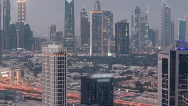 Filas de rascacielos en el distrito financiero de Dubai de día a noche timelapse. — Vídeos de Stock