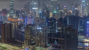 Dubai iş sahası kulelerinin modern mimarisine sahip Skyline gece zaman çizelgesi. Hava görünümü
