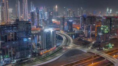 Dubai iş sahası kulelerinin modern mimarisine sahip Skyline gece zaman çizelgesi. Hava görünümü