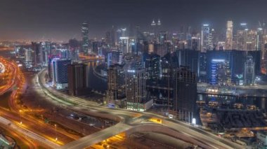 Dubai iş sahası kulelerinin modern mimarisine sahip Skyline gece zaman çizelgesi. Hava görünümü
