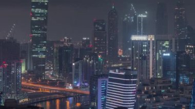 Dubai iş sahası kulelerinin modern mimarisine sahip Skyline gece zaman çizelgesi. Hava görünümü
