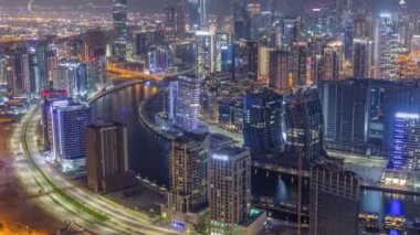 Dubai iş sahası kulelerinin modern mimarisine sahip Skyline gece zaman çizelgesi. Hava görünümü