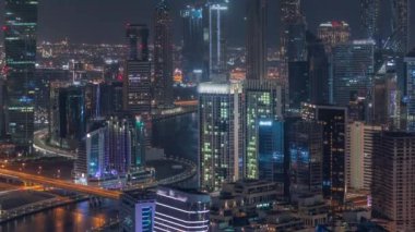 Dubai iş sahası kulelerinin modern mimarisine sahip Skyline gece zaman çizelgesi. Hava görünümü