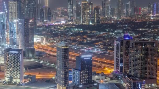 Rows of skyscrapers in financial district and business bay in Dubai aerial night timelapse. — Stock Video