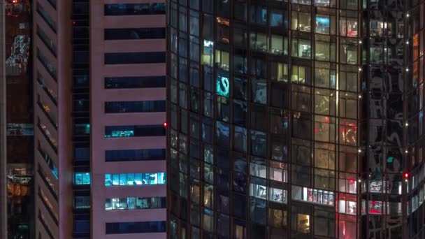 Ventanas en el exterior del edificio de oficinas en la noche con luces interiores en timelapse — Vídeo de stock