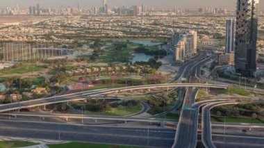 Yeşil çimenli ve göllü Golf sahasına hava manzaralı, arkasında villalar olan villalar zaman ayarlı..