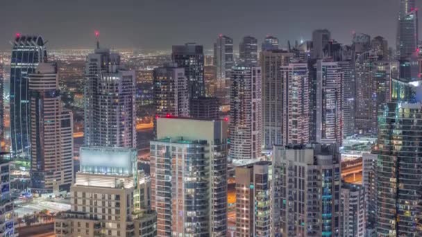 Dubai marina y los rascacielos JLT a lo largo de Sheikh Zayed Road timelapse noche aérea. — Vídeos de Stock