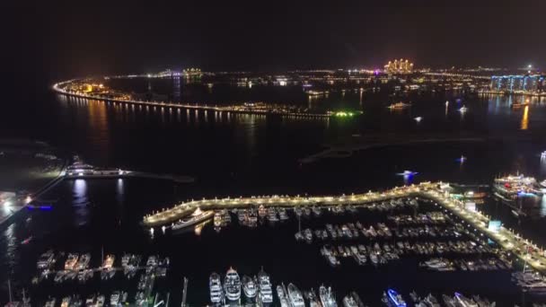 Palm Jumeirah met yahcts in de haven en Atlantis hotel bij nacht algemene uitzicht vanaf wolkenkrabber Dubai marina timelapse — Stockvideo