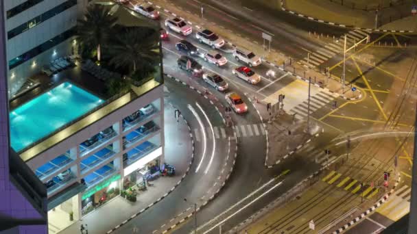 Traffic on intersection with tram at night timelapse from top, Dubai Marina — Stock Video