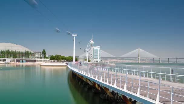 Pessoas praticando esportes no Passeio Ribeirinho sobre o rio Tejo. Torre e Ponte Vasco da Gama, Hotel e bonde aéreo. Parque das Nações hiperlapso temporal — Vídeo de Stock