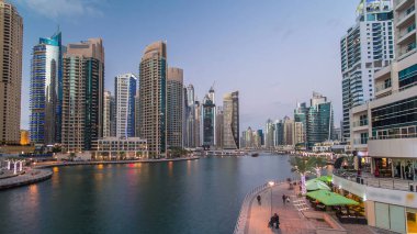 Dubai Marina rıhtımı, Dubai 'deki köprüden gece vardiyasına kadar uzanan kuleleri ve yatları olan Birleşik Arap Emirlikleri. Yapay kanalları ve gökdelenleri olan bir bölge.