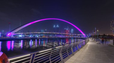 Dubai Su Kanalı üzerinde, gökdelenlerin ufuk çizgisi boyunca aydınlatılmış yaya köprüsü. Creek 'i Jumeirah Sahili' ne bağlıyor. Deira, Downtown ve Safa Park 'tan geçiyor. Arap Emirlikleri