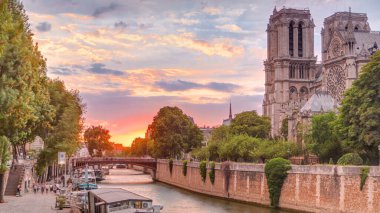 Fransa 'daki Notre Dame de Paris Katedrali üzerinde gün batımı manzarası. Başpiskoposluk Köprüsü 'nden hava görüntüsü. Tekne istasyonu ve rıhtım. Mimari ve çarpıcı gökyüzü simgeleri.
