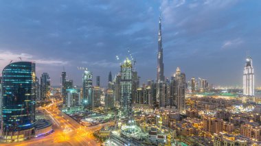 Dubai Şehir Merkezi 'nden geceye geçiş panoramik zaman dilimi. Geceleri büyük, fütüristik şehir üzerinde hava manzarası. Dubai 'nin gökdelenleri, Birleşik Arap Emirlikleri. Akşam gökyüzü çatıdan yükseliyor