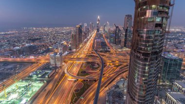 Dubai şehir merkezindeki ufuk çizgisi günden geceye geçiş zamanı. Şeyh Zayed kavşağındaki çok sayıda aydınlatma kulesiyle çatıdaki trafiğin görüntüsü.