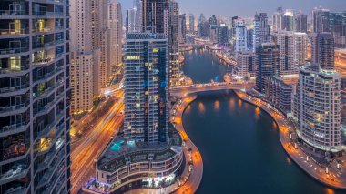 Dubai, Birleşik Arap Emirlikleri güneş battıktan sonra gece geçiş timelapse tüm Dubai Yat Limanı mesire ve kanal kayan yat ve tekne ile günler güzel hava üstten görünüm. Modern kuleleri ve yolda trafik.
