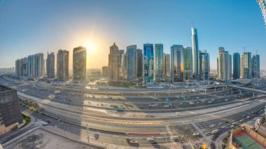Jumeirah göl kulelerinin gökdelenleri gün doğumunda Şeyh zayed yolunda ve metro hattında trafik varken. Dubai marinasından çatı manzarası