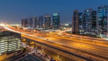Jumeirah göl kulelerinin hava panoramik görüntüsü gökdelenler günden geceye geçiş zamanı Sheikh zayed yolu ve metro hattı trafiği.