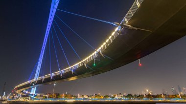 Fütüristik Dubai su kanal ışıklı gece timelapse hyperlapse, Birleşik Arap Emirlikleri, üzerinde yaya köprüsü. Cityscape arka plan üzerinde. Promenade görüntülemek