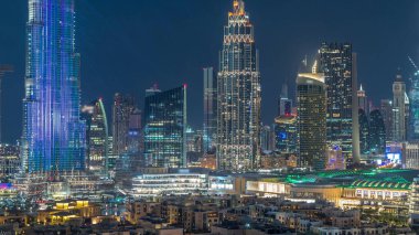 Dubai Şehir Merkezi 'nin ufuk çizgisi günden geceye geçiş zamanı Dubai, Birleşik Arap Emirlikleri' nin tepesinden panoramik manzaralı kuleler. Çember yollarda ve çeşmelerde trafik