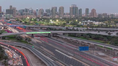 Dubai Golf Sahası 'nın arka plan hava gününden geceye geçiş zamanlarında yeşillik ve tekom bölgelerinden oluşan bir manzarası var. Şeyh zayed yolunda trafik kesişiyor.