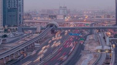 Dubai Marina 'dan Şeyh Zayed yoluna gece gündüz aydınlık gökdelenlerle geçiş zamanı, Dubai. Tramvayı olan trafik, köprüler ve metro istasyonları. Birleşik Arap Emirlikleri