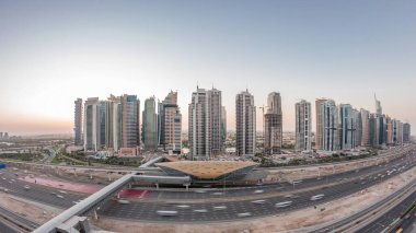 Dubai Marina 'dan Sheikh Zayed yoluna gece gündüz aydınlık gökdelenler ile hava panoramik görüntüsü, geçiş zamanı, Dubai. Trafik, köprüler ve metro istasyonu. Birleşik Arap Emirlikleri