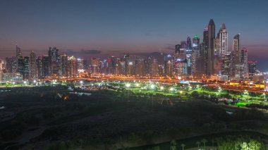 Dubai Marina gökdelenler ve gece geçiş timelapse, Dubai, Birleşik Arap Emirlikleri golf sahası gün. Gün batımından sonra Greens bölgesinden havadan görünüm
