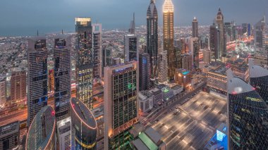 Sheikh Zayed Road ve Difc hava dan gece dubai, Bae gece geçiş timelapse yakınındaki binaların Silueti. Gün batımından sonra finans merkezi ve şehir merkezinde modern kuleler ve gökdelenler
