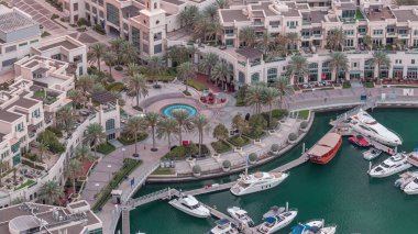 Dubai Marina Yürüyüşü 'nde çeşme ve palmiyeli Top View gece gündüz geçiş zamanı. Sabahları yat ve teknelerle aydınlatılmış.