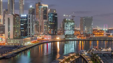 Günbatımından sonra, Business Bay hava sahasında lüks yatları olan güzel nehrin yanındaki gelecekteki gökdelenler geçiş zamanları, Dubai, Birleşik Arap Emirlikleri.