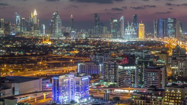 Şehir merkezinde büyük gökdelenler ve onlardan gelen ışıklar ve renkli gökyüzü, Dubai, Birleşik Arap Emirlikleri ile finans bölgesi Timelapse 'nin havadan görünüşü