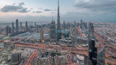Dubai Şehir Merkezi 'nin gökdelenleri ve Burj Halife' nin gece gündüz gökdelenleri ile fütüristik şehir manzarası. Gündoğumundan önce çatıdan modern kuleleri ve inşaatı olan sabah manzarası