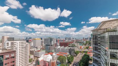 Singapur silueti, Victoria caddesi ve Ulusal Kütüphane hava zaman çizelgesi. Trafiği olan yeşil ağaçlar. Mavi gökyüzünde bulutlar