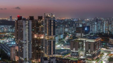 Apartman binaları ve Singapur zaman çizelgeleri olan gökdelenler. Sokakta trafik vardı. Gün batımında Skybridge bakış açısından bak