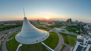 Khan Shatyr ve merkez iş bölgesi geçiş zamanı ile şehir merkezinde gün doğumuyla yükselen manzara. Çatıdan, Kazakistan, Astana, Orta Asya 'dan gün doğumundan önce havadan zaman geçişi.