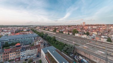 Brüksel Kuzey İstasyonu 'nun tren rayları, gelen ve giden trenlerle dolu. Schaerbeek akşam şehir manzarası kırmızı çatılar, sanayi bölgeleri ve bulutlu bir gökyüzü. Belçika