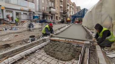 Çelik şebeke takviyesi yaptıktan sonra beton karıştırıcı hiperhızlandırıcı ile yolu açmak için hazır beton dökülüyor. Şehir caddesindeki tramvay raylarının yeniden inşası