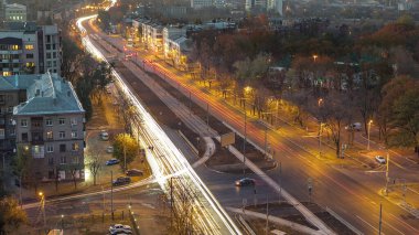 Yol trafiği olan hava manzarası, günden geceye geçiş zamanı. Günbatımından sonra yeni inşa edilen Moskova Bulvarı ve yerleşim bölgeleriyle yukarıdan Kharkiv şehri