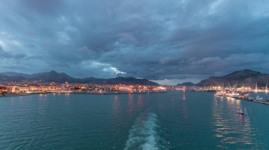 Gün batımından sonra açık denizde seyreden dalgalı ve limanlı deniz manzarası. Palermo kıyısı, İtalya