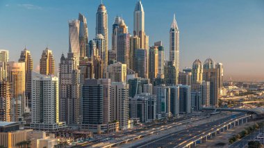 Dubai Yat Limanı gökdelenler hava üstten görünüm Jlt üzerinden sabah Dubai timelapse, BAE güneş doğarken sırasında. Modern kule uzun gölgeler aşağıya taşınması ve Şeyh zayed yolu üzerinde trafik ile.