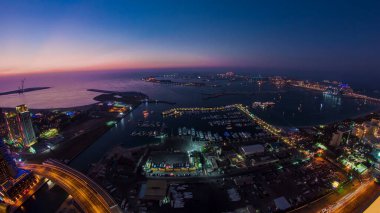 Dubai Marina Panorama 'dan gece gündüz hava görüntüsü. Gün batımından sonra ışığın Palm Jumeirah' a geçişi. Yat ve teknelerle yukarıdan manzara