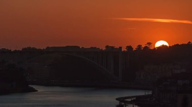 Sunset over old city Porto at river Duoro, with orange sky and the Arrabida bridge, Oporto, Portugal. Aerial view from above at evening