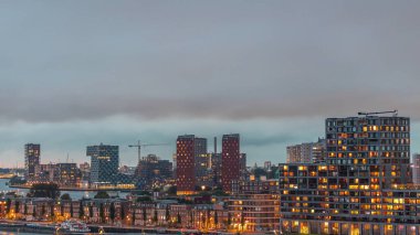 Rotterdam, Hollanda 'daki Katendrecht Yarımadası ve Maashaven Limanı' nın panoramik hava ve gece geçiş zamanı. Şehir silueti modern gökdelenler ve geleneksel Hollanda rıhtım evleri