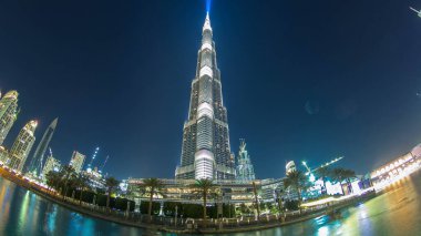 Burç Khalifa cepheden geceye geçiş zamanı Dubai, BAE 'de balık gözü. Işıklar yanıyor. Burj Halife dünyanın en yüksek binasıdır. Dubai şehir merkezinde Şeyh Zayed Yolu 'nda..