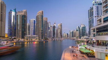Dubai Marina rıhtımı, Dubai 'deki köprüden gece vardiyasına kadar uzanan kuleleri ve yatları olan Birleşik Arap Emirlikleri. Yapay kanalları ve gökdelenleri olan bir bölge.